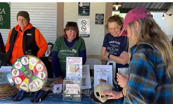 Volunteers at the Anastasia State Park booth interact with a festival attendee