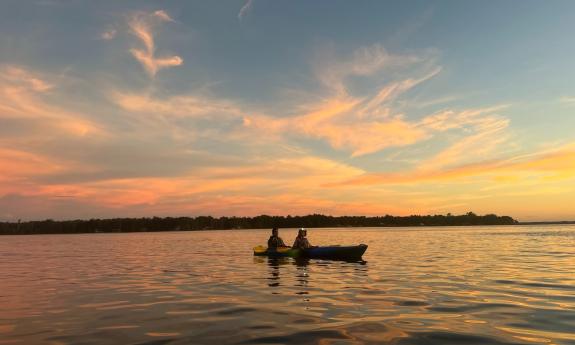 Two people in a tadem kayak on a river in St. Johns County