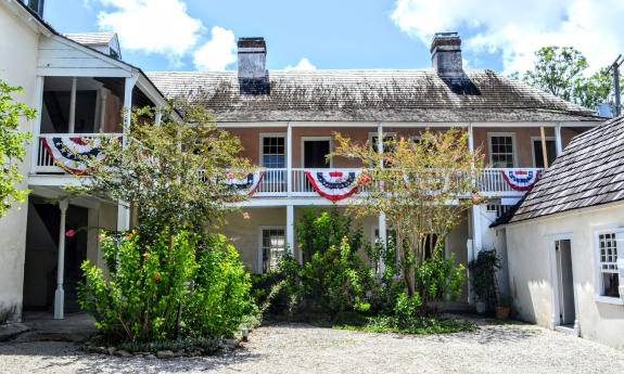 The courtyard of the Ximenez-Fatio House with patriotic bunting hanging from the balconies