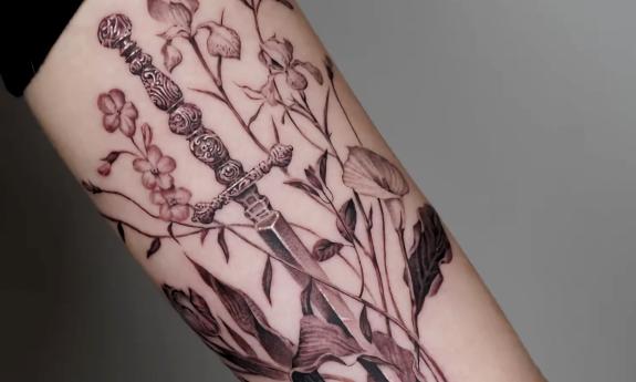 Detailed body art of a sword and flowers