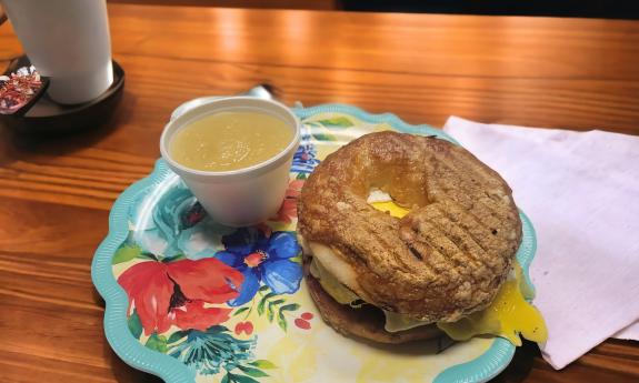 A bagel sandwich and a side of applesauce