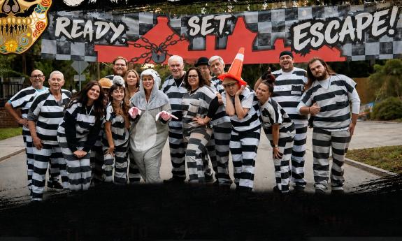 A group of costumed runners in prision black and white and one animal