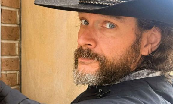 side view of Banjo Brown, in black cowboy hat
