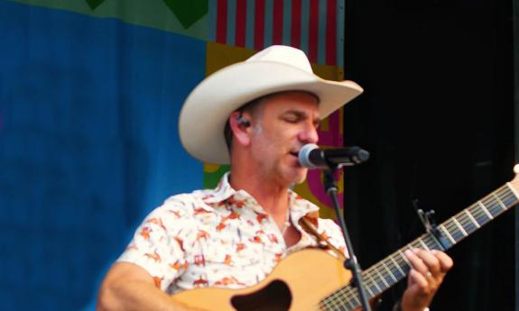 Songwriter Craig Campbell singing onstage, in white cowboy hat