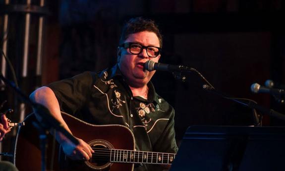 songwriter Gordie Sampson onstage with guitar, singing