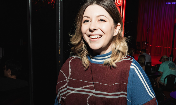 Jessie "Jetski" Johnson wears a striped shirt, smiles broadly, and poses for her fans. 