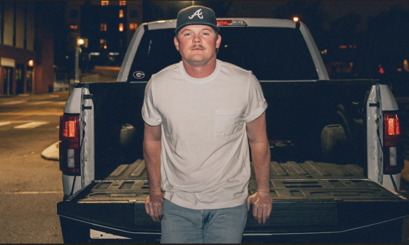 Justin Schools poses in front of his truck.