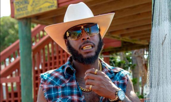 Outdoor shot of King Jay Da Blountman in plaid shirt and cowboy hat