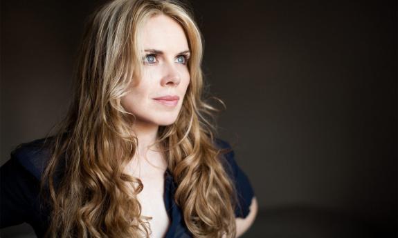 Mary Fahl poses against a black backdrop in a profile shot.