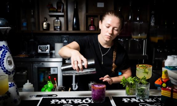 A bartender crafts a drink in the Pepper's Cantina
