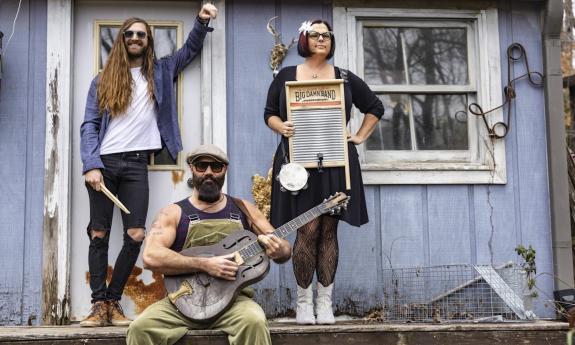 Bandmates from Reverend Peyton's Big Damn Band pose with their musical instruments.