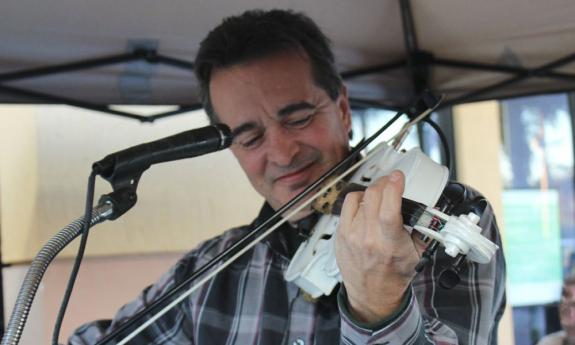 Fiddle player TR Zielinski playing his white fiddle, on stage