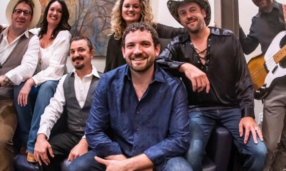 Bandmates from The Seven Wonders huddle together and strike a pose.