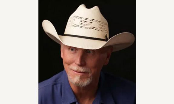 Songwriter Wynn Varble in white cowboy hat, smiling