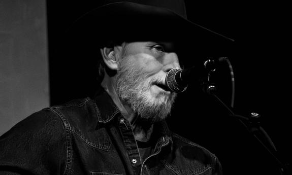Wynn Varble in black cowboy hat at microphone