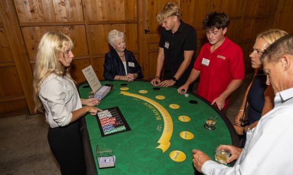 A group of people standing at a casino table for a charity event