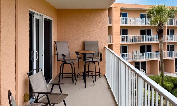 A patio deck with room for four chairs, two high and two low
