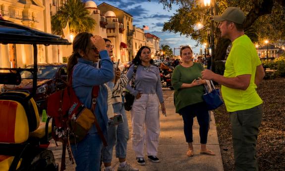 A tour group, listening to their guide on a ghost tour