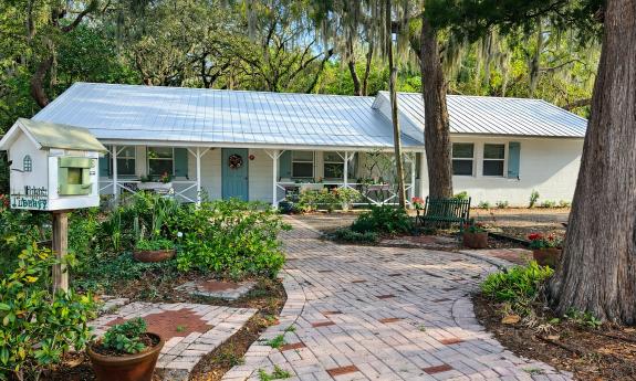 The exterior of the Garden Club of St. Augustine, a low white ranch house on a landscapped lot
