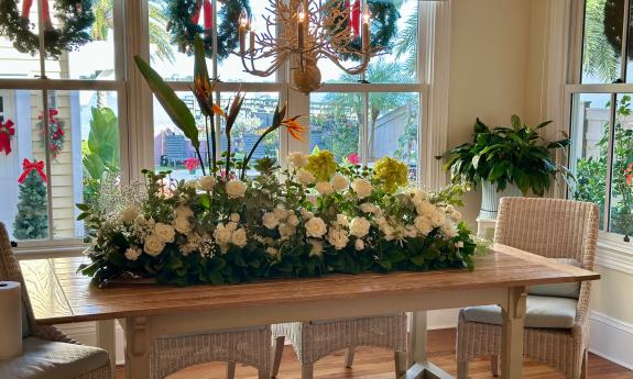A dining nook is decorated with wreaths and a large table display for the Holiday Tour of Homes