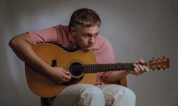 Jordan Burchel playing the acoustic guitar