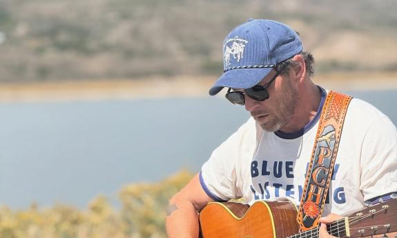 Patrick Hagerman playing his guitar in the wild