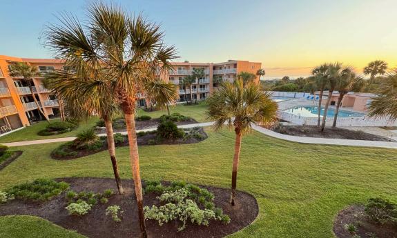 The view from the third-floor deck includes the center green space, pools, and ocearn