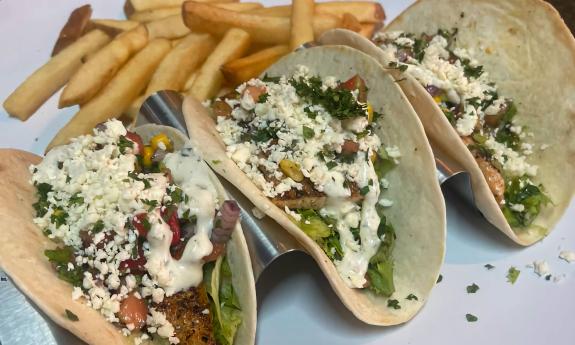 A plate of tacos and a side of fries