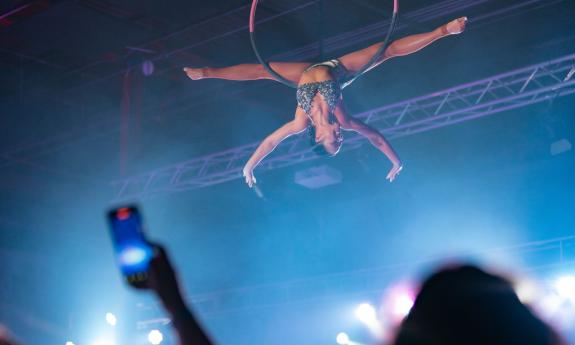 A woman high above spectators in a aerial act