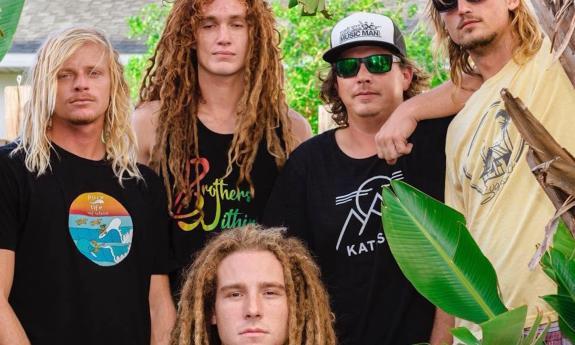 Bandmates from Brothers Within pose next to a plant.