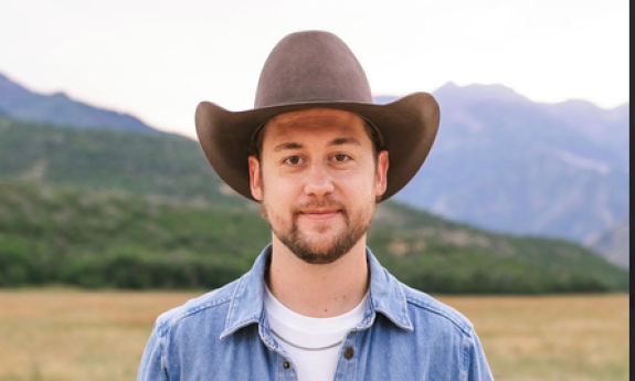 Songwriter Sam Banks in cowboy hat, standing outside
