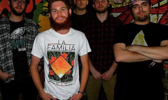 The Sons of Paradise bandmates flash bright smiles while posing together in front of a vibrant graffiti-covered wall.