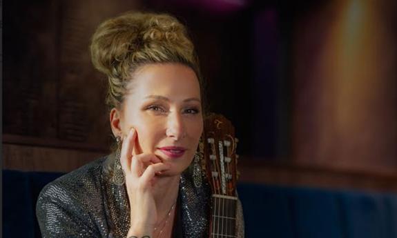 Yael Dray, AKA ZAZA Flamenca, smiling at camers, with hand to chin