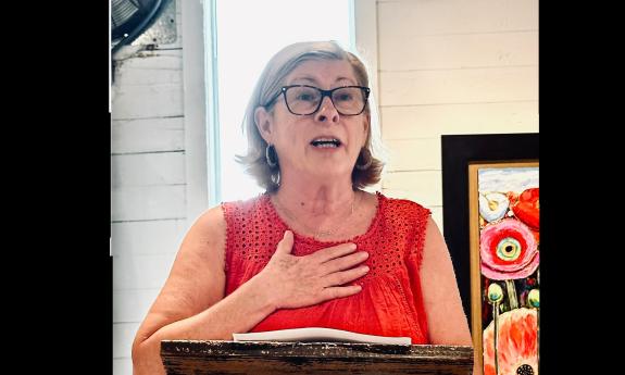 Poet and writer Amy Golden at a podium presenting her poetry