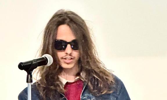 Poet and writer Ben Sullivan at a podium presenting his poetry