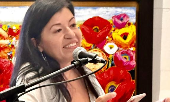 Poet and writer Brenda Guevara at a podium presenting her poetry