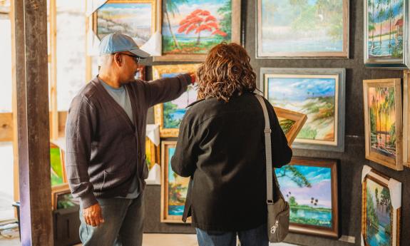 An artist showcasing his work to a customer