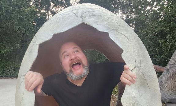 The comedian Marcus Crespo breaking out of a giant egg