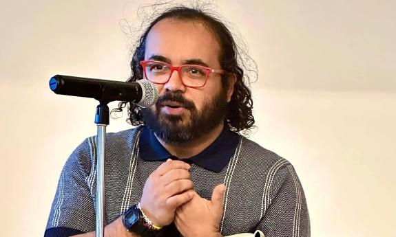 Poet and writer Maxwell Carrillo at a podium presenting his poetry