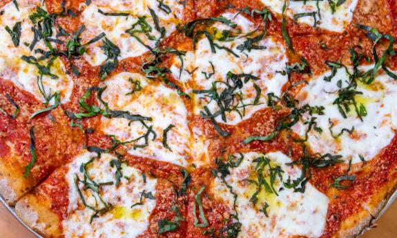 A pizza from Pizalley's with large dollops of ricotta cheese and fresh basil