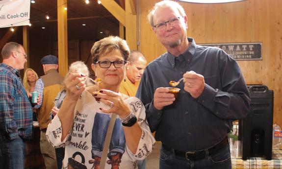 A couple standing and tasting samples of chili at the cookoff for Rethread