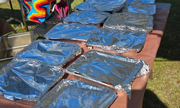 Tables filled with large foil trays of a seafood meal
