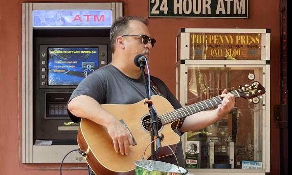 Musician Joe Schauer playing outside in the square at St. George Inn