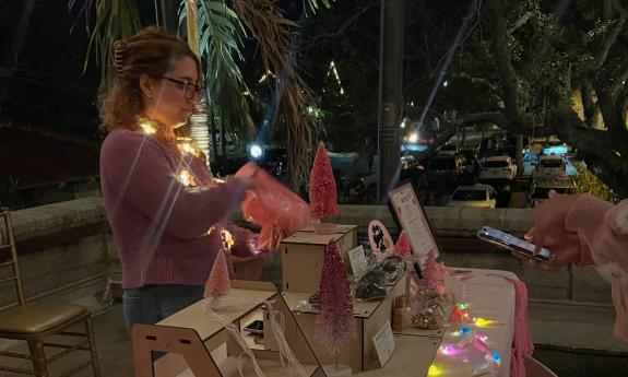 A vendor selling an item at the Lightner Holiday Market