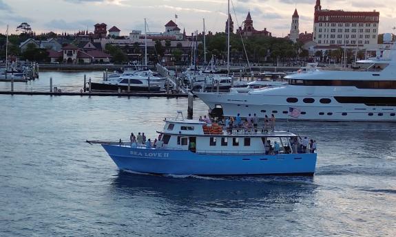 Sea Love II, a blue charter fishing and party boat, cruising past the City of St. Augustine