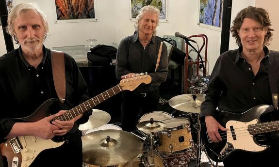 The trio, Sidewalk 65, standing together with their instruments