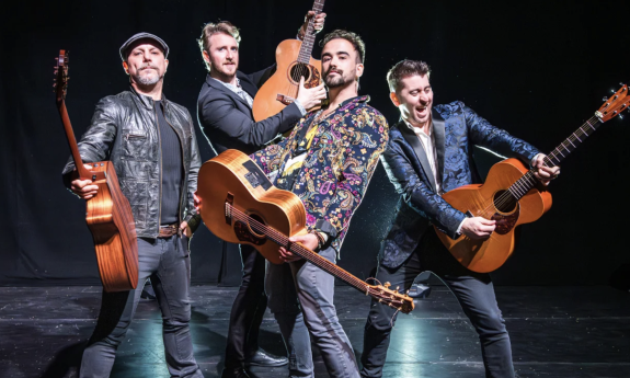 Bandmates from 40 Fingers pose with their musical instruments on stage.