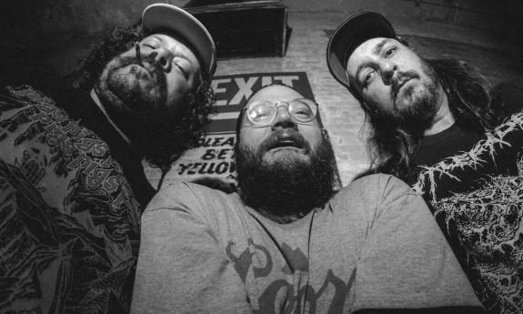 Bandmates from Billie's Burger Patrol pose in front of a brick wall.