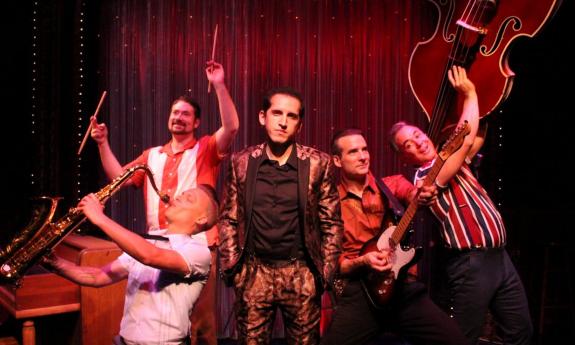 The Shakedown Shuffle pose with their musical instruments on stage.
