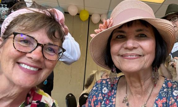 Two women in bright summer hats and dresses